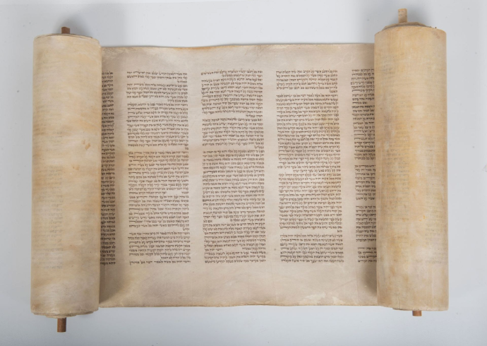 An ancient Torah parchment scroll opened to sacred text